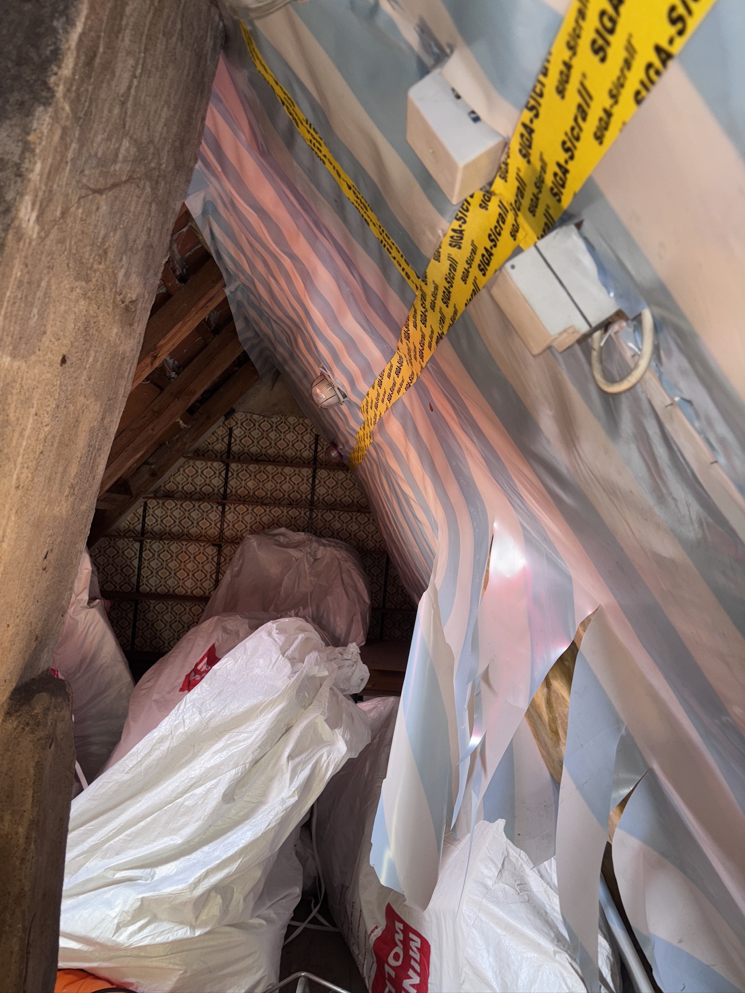Abgeschotteter Arbeitsbereich mit Folie und Klebeband während des Mineralwolle-Rückbaus