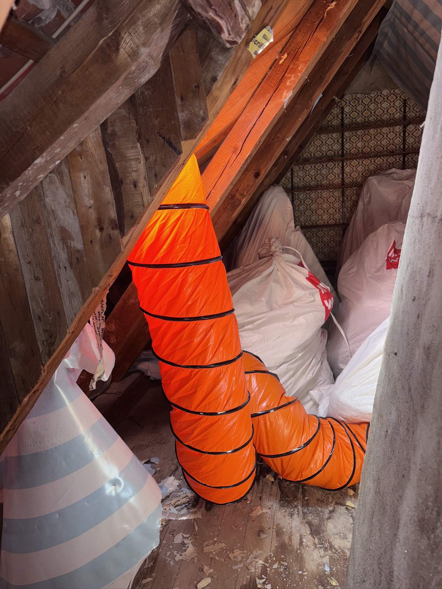 Rückbau kontaminierter Mineralwolle auf dem Dachboden, verpackt in reißfesten Säcken